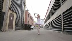 Young ballerina leaping in urban alley Stock Footage