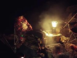 MS PAN Shot of group cooking food on bonfire at camping at night / Okutama, Tokyo, Japan Stock Footage