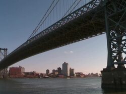 Beneath the Williamsburg Bridge and the east river with Brooklyn in the background late in the day Stock Footage