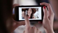 Two young women scroll through cute selfies on smartphone Stock Footage
