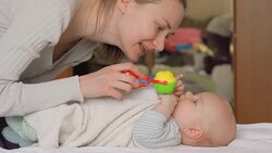 Mother and her baby playing with rattles. Stock Footage
