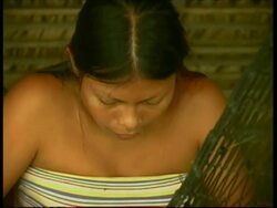 Woman sewing in hammock, Ambre tribe, CU zoom out to MS, Panama, Central America Stock Footage