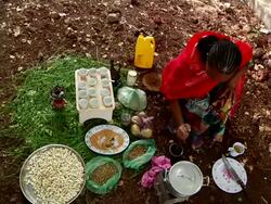 Woman pounding roasted coffee grains for coffee ceremony Stock Footage