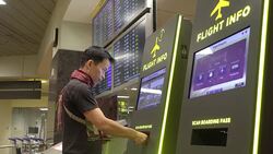 Asian man check flight information with machine in airport terminal Stock Footage