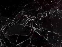 Window pane shattering and  falling against black background, slow motion Stock Footage