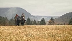 DS Couple riding horses in relaxed manner across mountain meadow Stock Footage