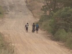 African ladies walking on dirt road - HD & PAL Stock Footage