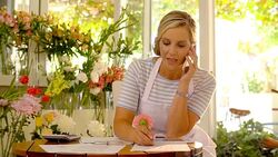 Florist talking on cell phone in flower shop Stock Footage