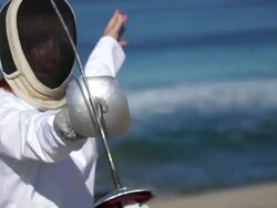 A man and woman fencing on the beach. - Slow Motion Stock Footage