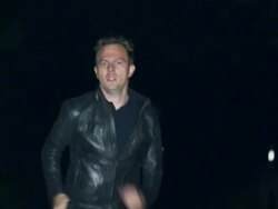 Man with gun running on street Stock Footage