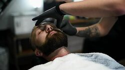 Close-up of beautiful attractive adult man with beard in a barber shop Stock Footage