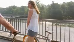 Couple pushing bicycles along river Stock Footage
