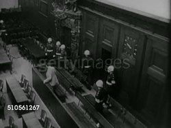 1945: NUREMBERG TRIALS: Hermann Goering into Defendants Dock, HA TD WS Man entering behind, unidentified male holding papers to face, Wilhelm Keitel taking seat next to Joachim von Ribbentrop [VO James B. Donovan].    War Crimes, military tribunal Instructional Video