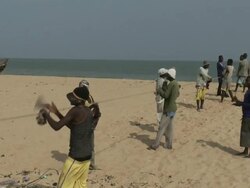 Reverse Mid Shot Beninese fishermen hauling net Stock Footage