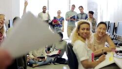 Teacher talking to smiling students in computer class Stock Footage