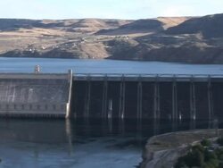 Wide Shot pan-right - A huge dam creates a reservoir / Grand Coulee Dam, Washington Stock Footage