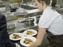 POV waitress taking prepared plates from the plating area in a restaurant kitchen to carry them to the dining room Stock Footage