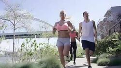Group of young adult runners running in the city along the waterfront Stock Footage