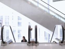  WS Businesswoman ascending escalator in office building and walking away / Seattle, Washington, United States Stock Footage