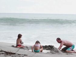 MS Man, boy and girl build sandcastle on beach with wave break and rocks  / Montezuma, Puntarenas, Costa Rica Stock Footage