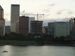 WS PAN View of Small boat motors past Portland Oregon at sunset, crossing with faster boat near Hawthorne bridge / Portland, Oregon, United States  Stock Footage