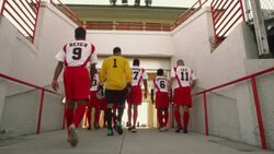 A men's soccer team walks away through a stadium door in Pennsylvania. Stock Footage