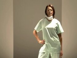 MS ZO Woman in medical scrubs modeling on catwalk while audience applauds / London, England, UK Stock Footage