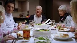 Family enjoying at the dinner table eating and chatting Stock Footage