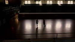 Two basketball players play a game of one-on-one in a gym illuminated by sunlight coming through the windows. Stock Footage