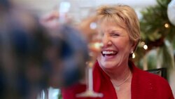 Joyful grandmother raises glass to toast and clink with family at dinner table Stock Footage