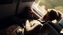 CANTED MEDIUM SHOT young man looks out window while riding moving train Stock Footage