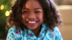 Excited young girl smiles big, waiting to open presents on Christmas morning Stock Footage