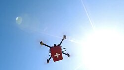 First aid kit carried across sunny sky by a drone Stock Footage