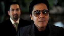 A Latino man with a goatee looks over the shoulder of an Asian man wearing dark sunglasses. Stock Footage