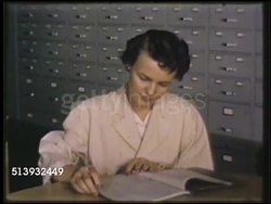 1935: FIRESTONE RECORD LIBRARY: COLOR: VS Firestone scientists, chemists, in library, female looking at files, male putting 'Research Reports' book back into shelf, pulling out another, reading. Instructional Video