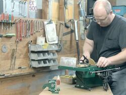 worker measures diamond blade during assembly of trim saw machine designed for cutting and grinding gem stones / Redlands, California, USA Stock Footage