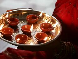 CU Woman holding tray with lit oil lamps / Singapore Stock Footage