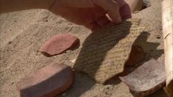 An archaeologist examines broken pieces of pottery and other artifacts. Stock Footage