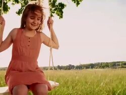 Young girl having fun swinging on a tree swing Stock Footage