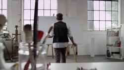 Artist starts painting on canvas Stock Footage
