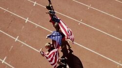 Happy track & field athletes hugging and running with American flags Stock Footage