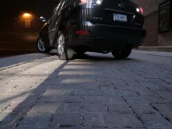 CU of permeable alleyway, Lexus SUV backs up, drives away Stock Footage