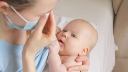Sick mother sneezing and breastfeeding her baby Stock Footage