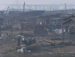 MS View of desolated land with men working and resting with pigs, trashes, smoke and cross bridge / Lagos, Nigeria Stock Footage