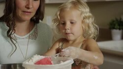 Close up panning shot of mother and daughter measuring flour for baking / Orem, Utah, United States Stock Footage