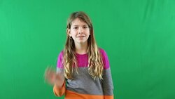 A preteen girl looking at the camera and smiling in front of a green screen Stock Footage