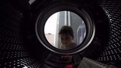 Little boy looks into the empty drum washing machine Stock Footage