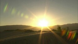 Colorful coronas form around a blazing desert sun. Stock Footage