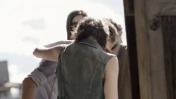 Young woman puts her arm around boyfriend as they sit on wooden fence and talk with friends in Texas ghost town Stock Footage