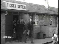 1946: DISCHARGE FROM SERVICE: Sign: Separation Center. Soldiers in coats carrying duffle bags walking out of Ticket Office building door. VS Newspaper headlines related to housing shortage, 8 million homes needed...Housing Outlook Bleak for Low Income Instructional Video
